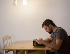 Un noi llegeix un llibre assegut a la taula del menjador