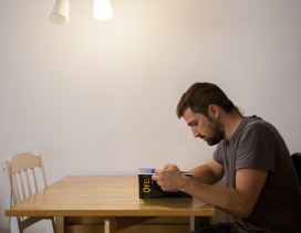 A man reading a book seating at a table