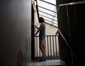 A woman closes the door of her house