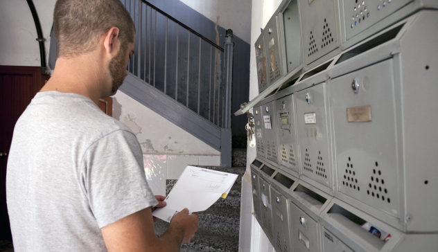 Un hombre mira el correo de su buzón